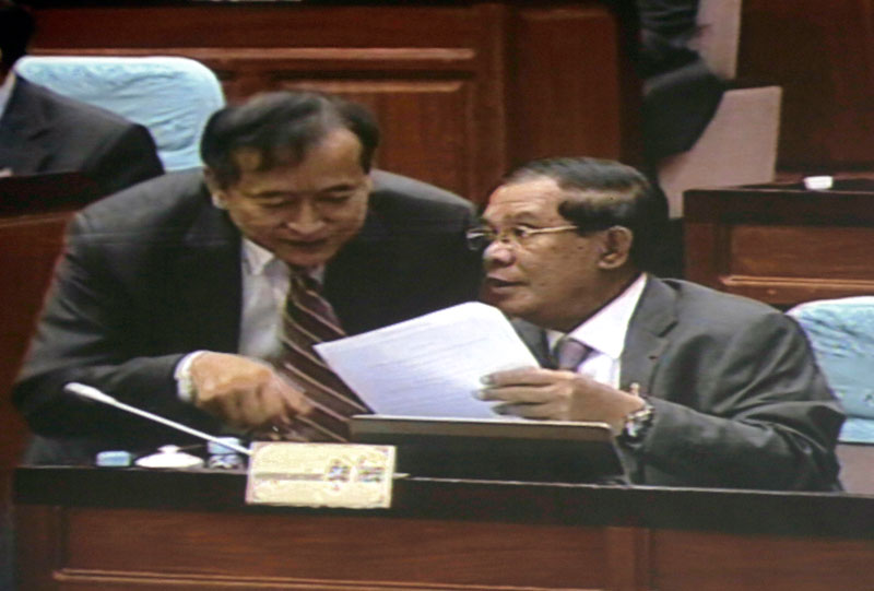 Opposition leader Sam Rainsy speaks with Prime Minister Hun Sen in the chamber of the National Assembly prior to adjourning for a private meeting, in an image captured from a television screen in the Assembly's pressroom. (Siv Channa/The Cambodia )