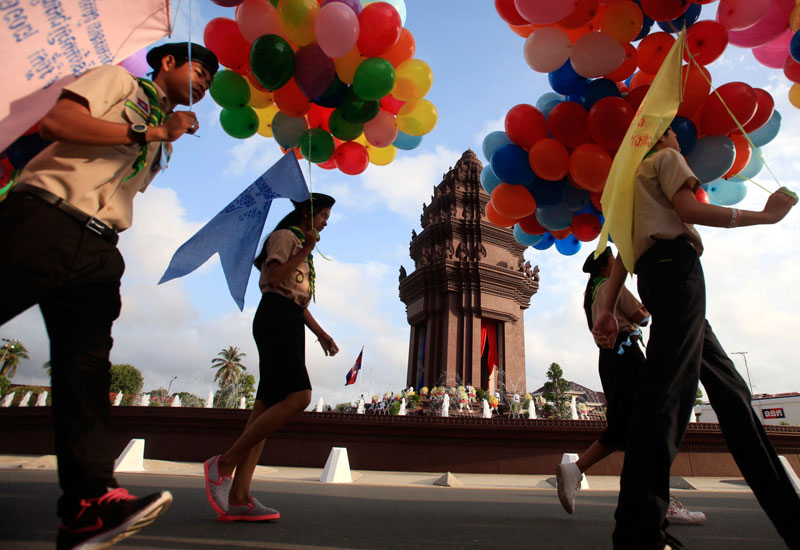 Revelers Celebrate 61st Anniversary of Independence 1 Scouts carry balloons as they walk around Independence Monument in Phnom Penh on Sunday during a celebration marking the 61st anniversary of Cambodia's independence from France. (Pring Samrang/Reuters)