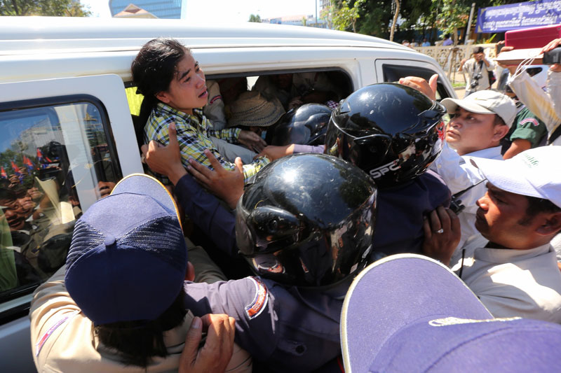 Daun Penh district security guards push anti-eviction activist Tep Vanny into a van following a scuffle in front of City Hall in Phnom Penh on Monday. (Satoshi Takahashi)