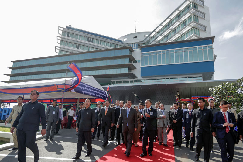 Prime Minister Hun Sen, center left, and Royal Phnom Penh Hospital founder Prasert Prasarttong-Osoth, talk following the opening of the hospital Tuesday. (Siv Channa/The Cambodia Daily)