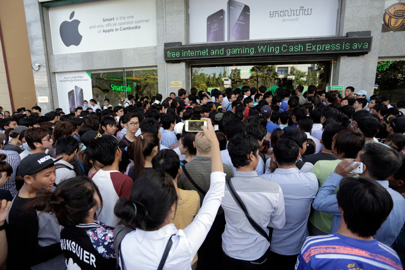 Hundreds of customers wait outside the Phnom Penh headquarters of mobile phone operator Smart on Monivong Boulevard on Friday morning for the official release of Apple's new iPhone 6. (Siv Channa/The Cambodia Daily)
