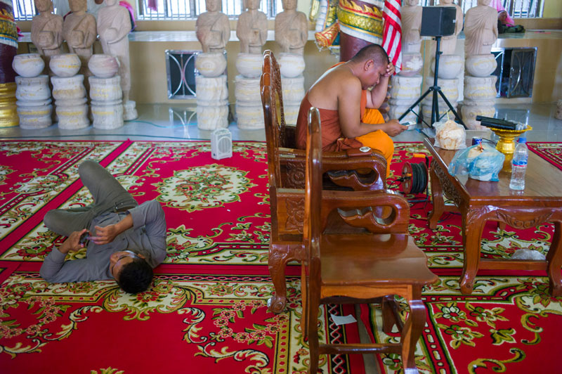 Activist monk Loun Sovath uses his smartphone at Samakki Raingsey pagoda in Phnom Penh on Wednesday. (John Vink)