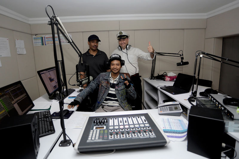 Jerry Costa, left, Kosal Khiev, center, and Tikei Pere pose for a photo at the Radio One FM103.7 studio in Phnom Penh on Tuesday. (Siv Channa/The Cambodia Daily)