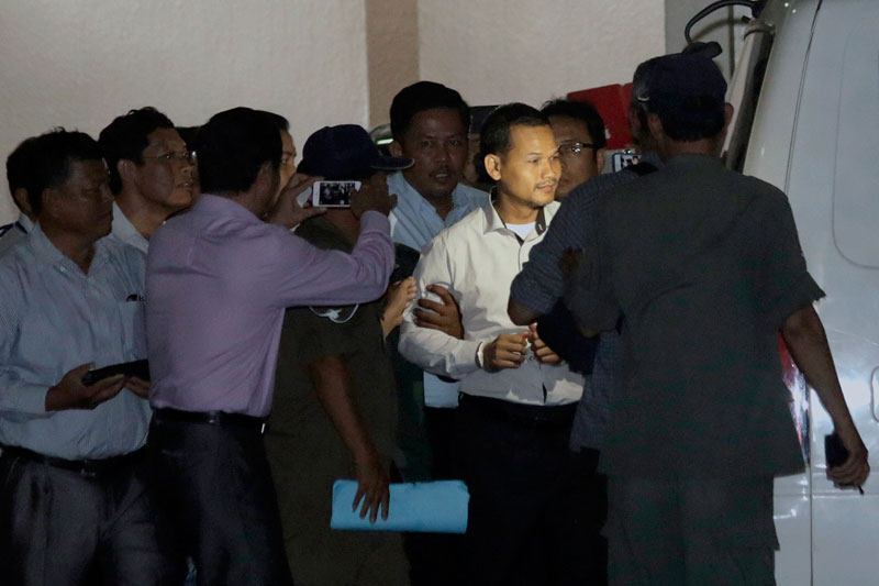CNRP official Meach Sovannara is escorted to a police van at the Phnom Penh Municipal Court on Tuesday. (Siv Channa/The Cambodia Daily)
