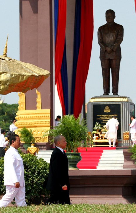 King Norodom Sihamoni, center, walks past a statue of his late father on Friday at the official unveiling of the memorial monument to the revered King Father Norodom Sihanouk, who died on October 15, 2012. (Siv Channa)