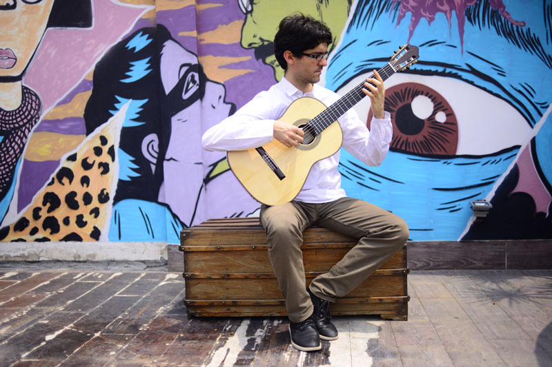Musician Salvatore Foderà demonstrates the technique for playing classical guitar. (Lauren Crothers/The Cambodia Daily)