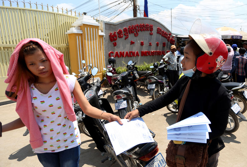 A union member hands out flyers outside the Canadia Industrial Park in Phnom Penh on Wednesday, urging garment factory workers to join a nationwide stay-at-home strike starting April 17. (Siv Channa)