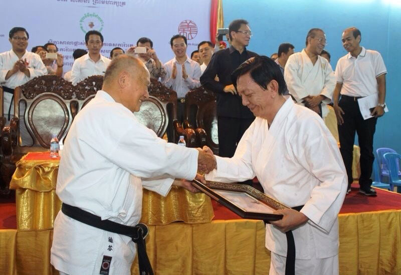 Water Resources Minister Lim Kean Hor, right, shakes hands with a visiting Japanese karate master at a ceremony in Phnom Penh to mark Mr. Kean Hor's new black belt in karate. (Chan Youttha)