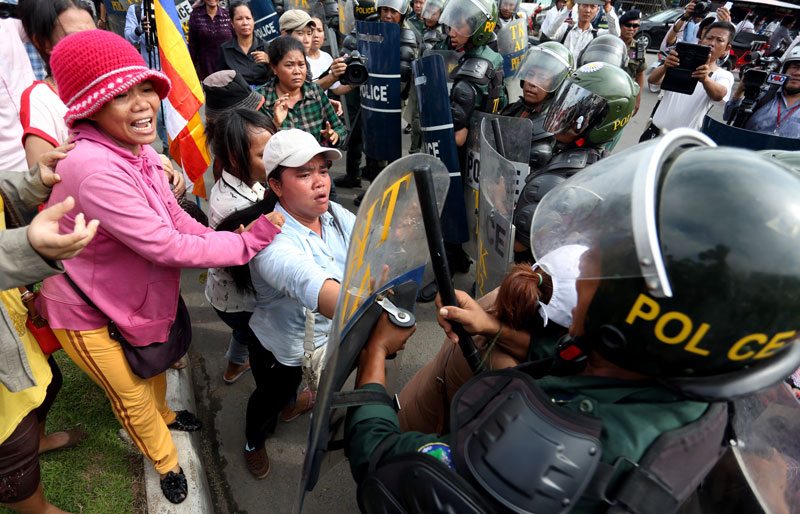 Villagers from three communities embroiled in long-running land disputes clash with riot police during a protest outside the Council of Ministers building on Friday. (Siv Channa/The Cambodia Daily)