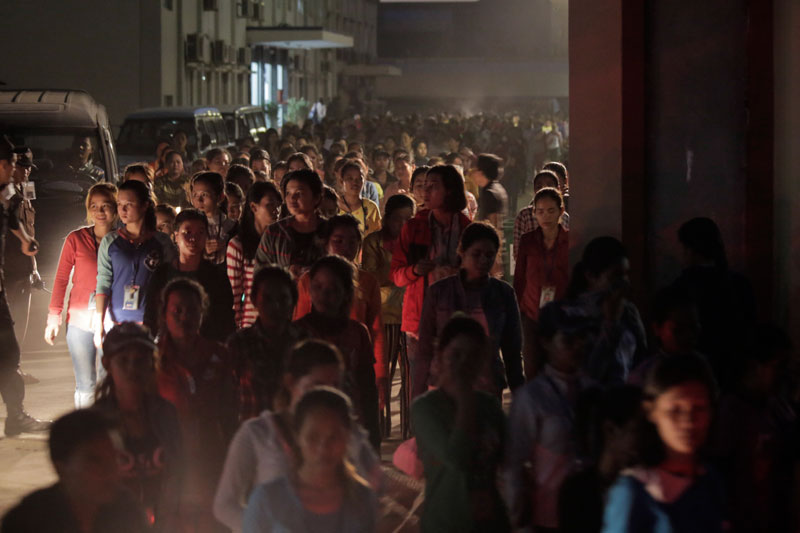 Late-shift workers leave the Grand Twins International garment factory in Phnom Penh's Pur Senchey district on Monday evening. (Siv Channa/The Cambodia Daily)