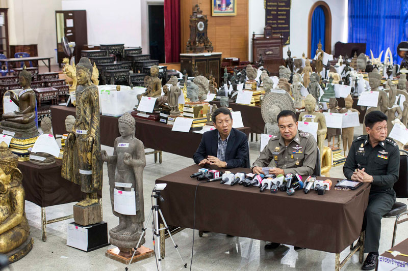 Thai police chief General Somyot Poompanmuang, center, talks to reporters last month as he sits among statues seized from Lieutenant General Pongpat Chayaphan, former head of the Thai central investigation bureau. (Reuters)