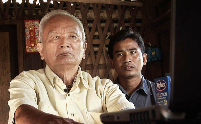 Filmmaker Thet Sambath, right, sits with Nuon Chea in a still from the documentary 'Enemies of the People.'