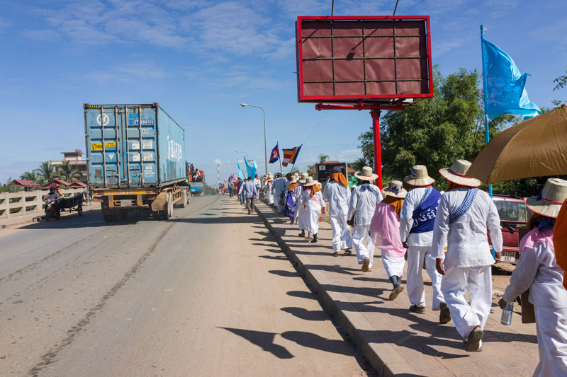 Activists from Takeo province walk along National Road 2 on Tuesday on their way to Phnom Penh to mark Human Rights Day today. Since Friday, more than 600 activists and monks have been marching to the capital from across the country. Several groups on Tuesday came up against police blockades, while others were locked out of the pagodas where they had planned to spend the night. (John Vink)