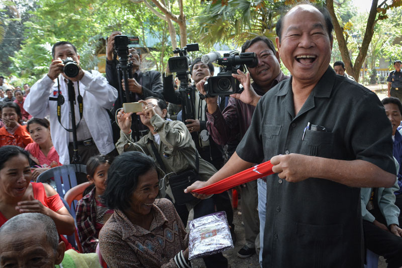 Health Minister Mam Bunheng distributes socks Thursday to villagers in Battambang province's Sangke district, where more than 100 people have tested positive for HIV in a mysterious outbreak of the virus in Roka commune. (Alex Consiglio/The Cambodia Daily)
