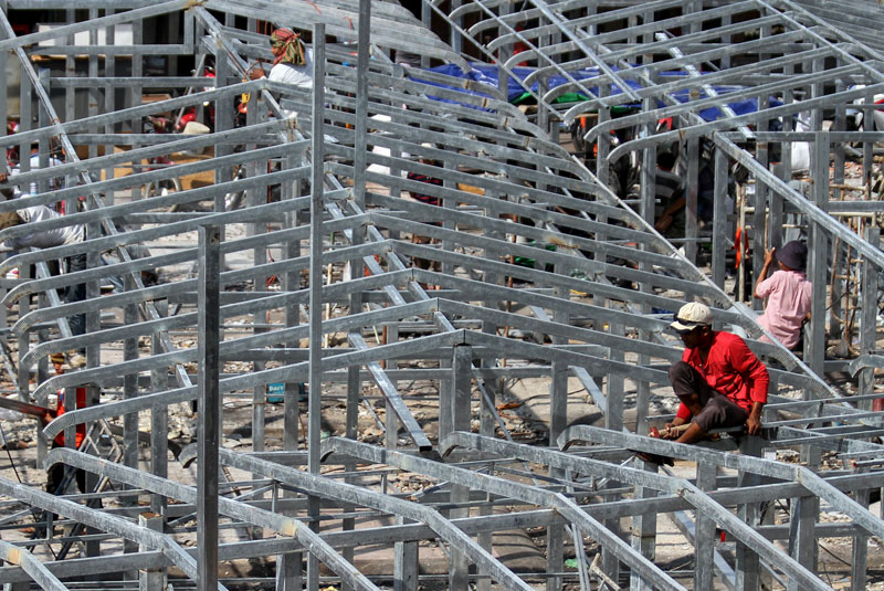 Construction workers Tuesday rebuild a section of Phnom Penh's Phsar Chas that was destroyed when a fire ripped through the market last week. (Siv Channa/The Cambodia Daily)