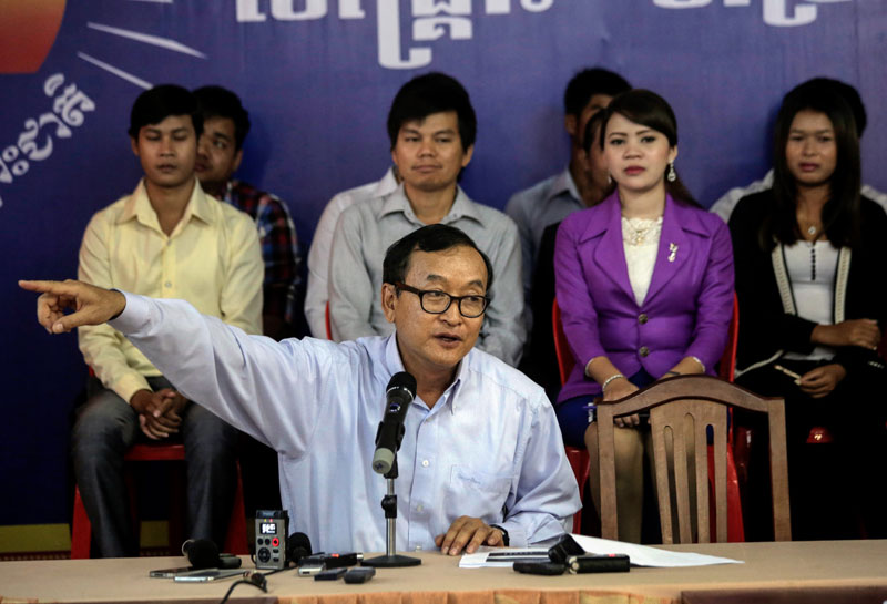 Opposition leader Sam Rainsy points to a slideshow Tuesday during a press conference he called to announce that his Facebook page has received one million 'likes.' (Siv Channa/The Cambodia Daily)