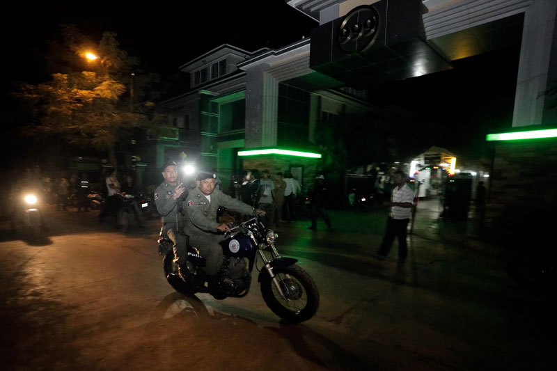Police drive by Borey 999 in Meanchey district's Boeng Tompun commune while searching for Major General Thong Sarath on Wednesday night. (Siv Channa/The Cambodia Daily)