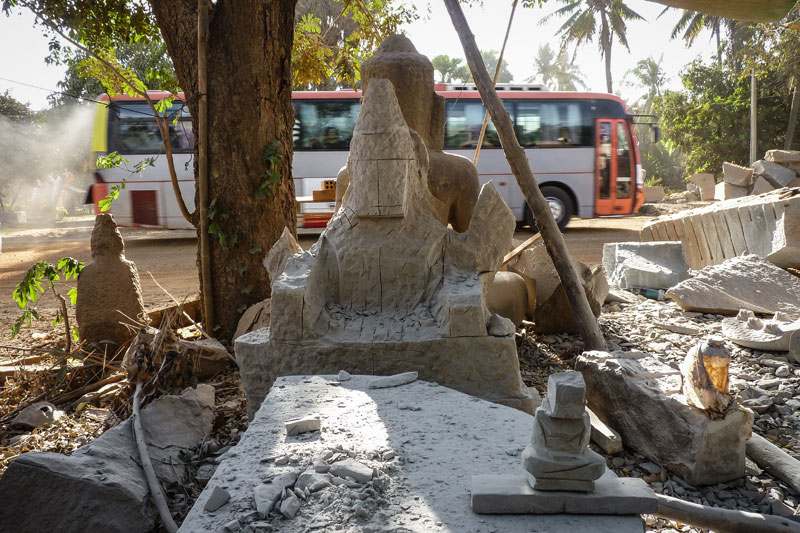 A bus passes unfinished statues in Samnak village, Kompong Thom. (Anthony Jensen/The Cambodia Daily)