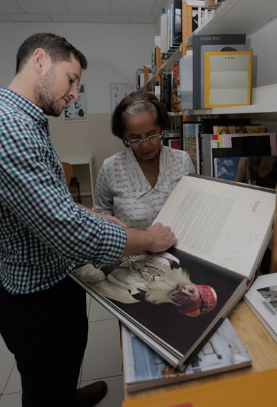 Bookbinder Mao Thach discusses book preservation with Simon Gardan. (Siv Channa/The Cambodia Daily)