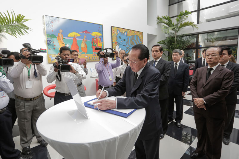 Foreign Minister Hor Namhong signs a letter at the French Embassy in Phnom Penh on Monday, paying respects to the victims of recent terrorist attacks, including a massacre at the Paris offices of satirical newspaper Charlie Hebdo. (Siv Channa/The Cambodia Daily)