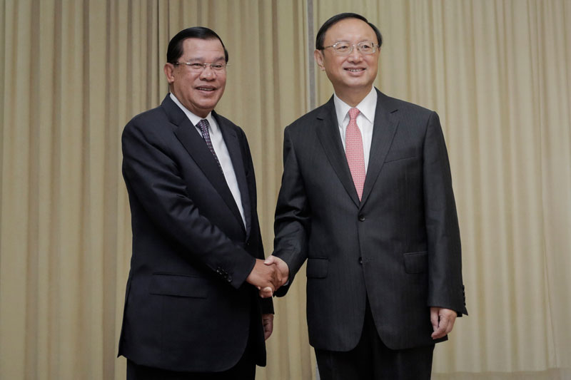 Prime Minister Hun Sen, left, shakes hands with Chinese State Councilor Yang Jiechi during a meeting at Mr Hun Sen's office on Wednesday. (Siv Channa/The Cambodia Daily)