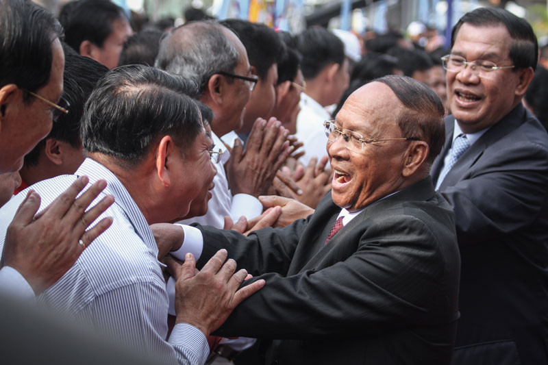 National Assembly President Heng Samrin, second from right, and Prime Minister Hun Sen, right, greet CPP supporters and officials during celebrations at the ruling party's Phnom Penh headquarters in 2015 to mark the January 7, 1979, overthrow of the Pol Pot regime. (Siv Channa/The Cambodia Daily)