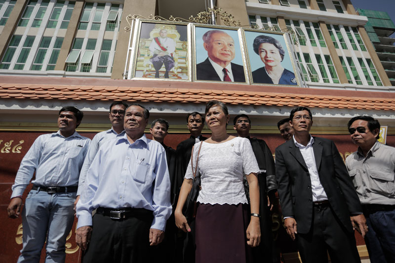 CNRP lawmakers Ho Vann, third from left, and Mu Sochua, center, stand in front of the Phnom Penh Municipal Court on Thursday after being ordered by the presiding judge to leave the hearing of 11 opposition activists. (Siv Channa/The Cambodia Daily)