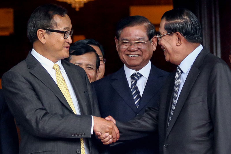 Opposition leader Sam Rainsy, left, and Prime Minister Hun Sen shake hands after the CPP and CNRP negotiated an end the country’s political crisis at the Senate in Phnom Penh in July. (Siv Channa/The Cambodia Daily)