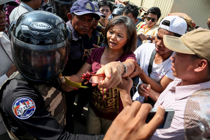 CNRP lawmaker Mu Sochua faces off with Daun Penh district security guards after being forced out of Phnom Penh’s Freedom Park in 2014. (Siv Channa/The Cambodia Daily)