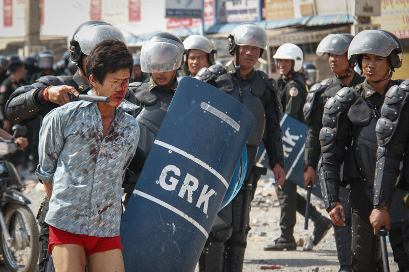 Military police escort a bloodied protester away from Veng Sreng Street in Phnom Penh in January. (Neou Vannarin/The Cambodia Daily)