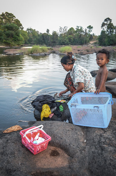 A woman washes clothes in the waters of the Areng River last week. (Zsombor Peter/The Cambodia Daily)