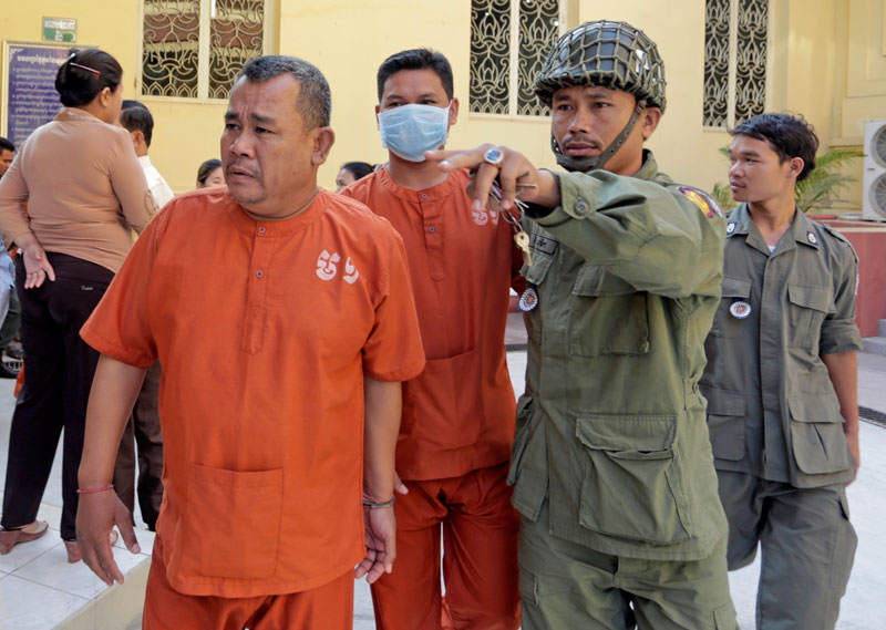 CNRP district councilor Soum Vuthy, left, is escorted to his bail hearing at the Supreme Court on Friday. (Siv Channa/The Cambodia Daily)
