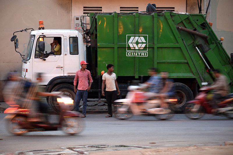 Motorists drive past a Cintri truck stopped on the side of a street in Phnom Penh yesterday. (Matt Walker)