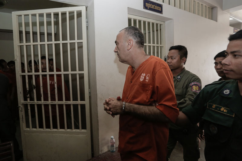George Moussallie, who is accused of sexually abusing six boys aged under 12, is escorted to a holding cell at the Phnom Penh Municipal Court after his trial on Tuesday. (Siv Channa/The Cambodia Daily)