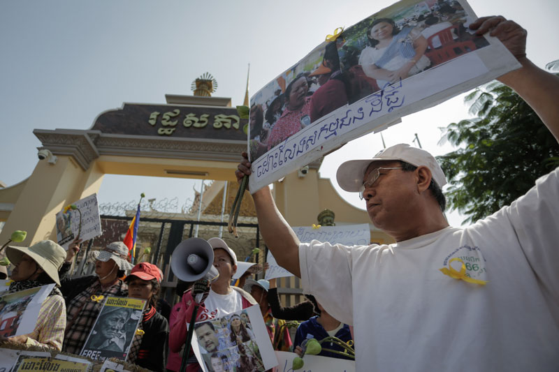 A protester holds up a sign calling for the release of 19 jailed activists outside the National Assembly on Thursday. (Siv Channa/The Cambodia Daily)