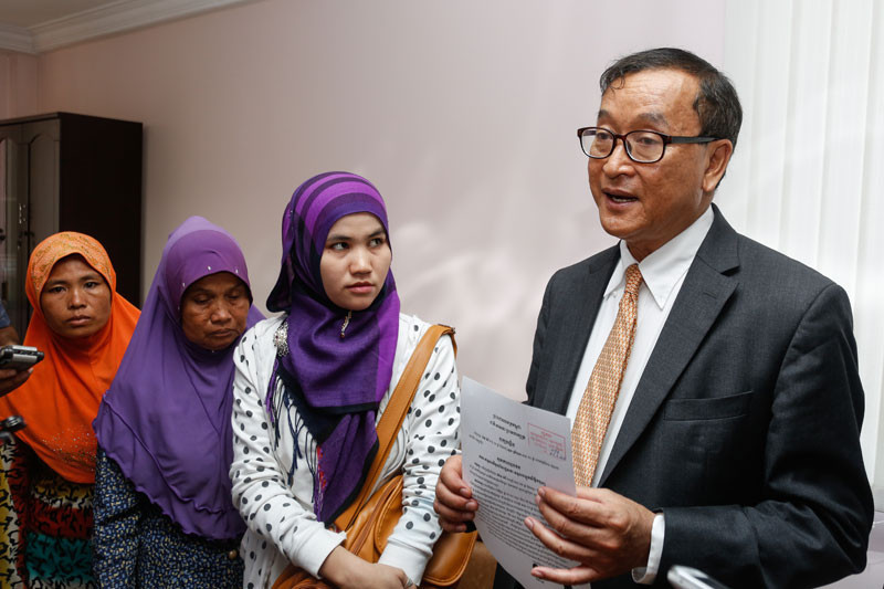 Cham Muslim women, along with a translator, look on as opposition leader Sam Rainsy speaks to the media about their daughters, who were trafficked to Malaysia, at the National Assembly in 2015. (Siv Channa/The Cambodia Daily)
