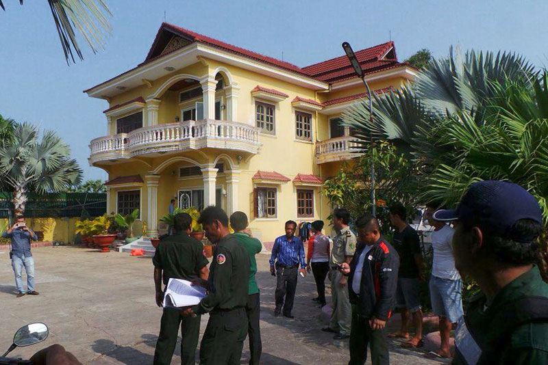 Police on Saturday stand near a Sihanoukville villa where officers arrested two Russians involved in a fight at the Queenco Casino and Hotel. (Photo supplied)