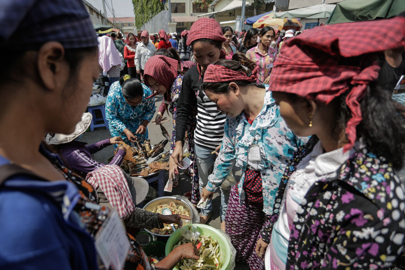 Garment workers buy lunch Monday outside the Hoyear Garment factory in Phnom Penh's Meanchey district. (Siv Channa/The Cambodia Daily)