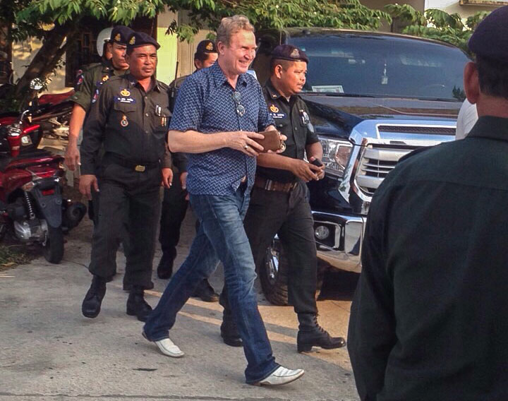 Russian businessman Nikolai Doroshenko walks with military police after being arrested on fraud charges at his family's Snake House restaurant in Sihanoukville on Wednesday. (Seth Sokhan)