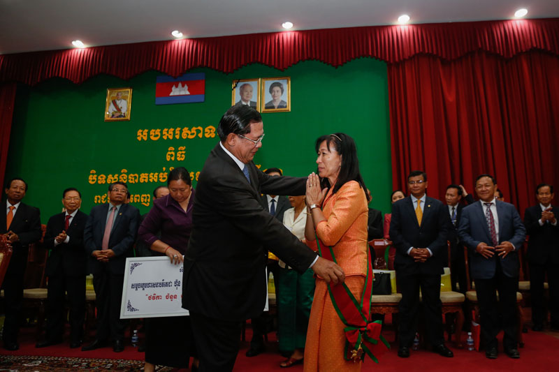 Prime Minister Hun Sen congratulates Neang Phalla on her top 10 finish in the Global Teacher Prize at the Ministry of Education's annual meeting Thursday. (Siv Channa/The Cambodia Daily)