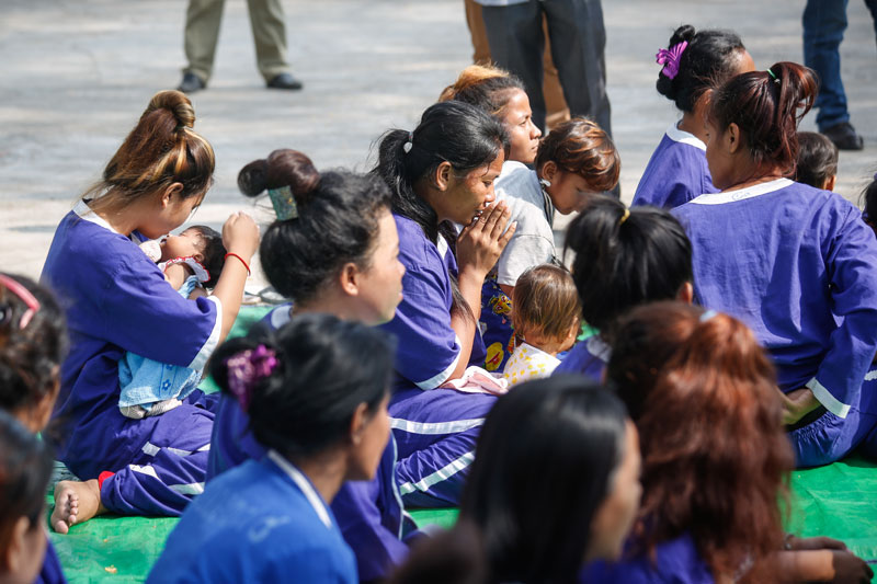 Inmates sit outside Prey Sar prison's Correctional Center 2 in Phnom Penh on Sunday ahead of the release of 22 female inmates across the country who are either pregnant or were jailed with their young children. (Siv Channa/The Cambodia Daily)