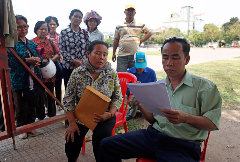 Kong Chamroeun, secretary of Prime Minister Hun Sen's Cabinet, looks over a petition on Friday from representatives of 163 families caught in a dispute over a plot of land in Phnom Penh's Sen Sok district. (Siv Channa/The Cambodia Daily)