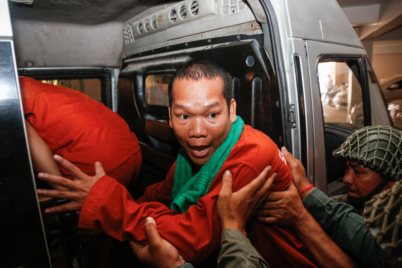 Defrocked and imprisoned monk Soeung Hai is escorted into a police van after being questioned at the Phnom Penh Municipal Court on Wednesday. (Siv Channa/The Cambodia Daily)