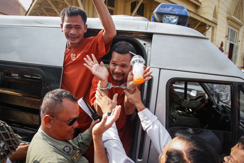 CNRP activist Ouk Pich Samnang, left, and CNRP official Meach Sovannara are escorted into a police van Wednesday after their bail hearing at the Supreme Court. (Siv Channa/The Cambodia Daily)