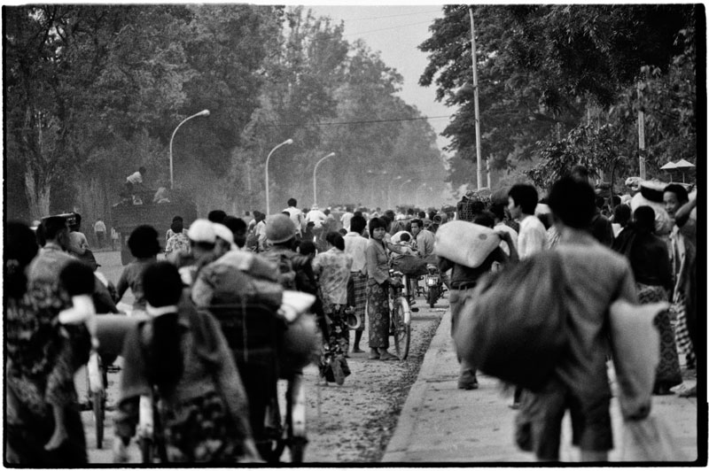 People gather in the late afternoon of April 16, 1975, on Monivong Boulevard, having fled the city’s suburbs where war was raging. (Roland Neveu)