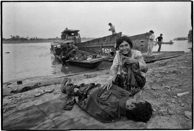 In March 1975, a woman crouches over a government soldier whose body was brought back from the front line south of Phnom Penh. (Roland Neveu)