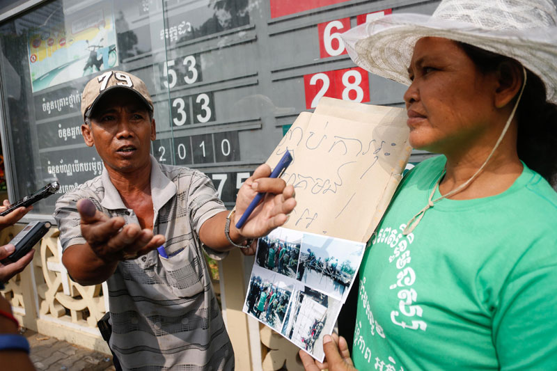 Boeng Chhouk resident Touch Sam On speaks with reporters in front of Phnom Penh City Hall on Wednesday during a protest against Russei Keo district's efforts to evict him and about 600 other families from their homes. (Siv Channa/The Cambodia Daily)
