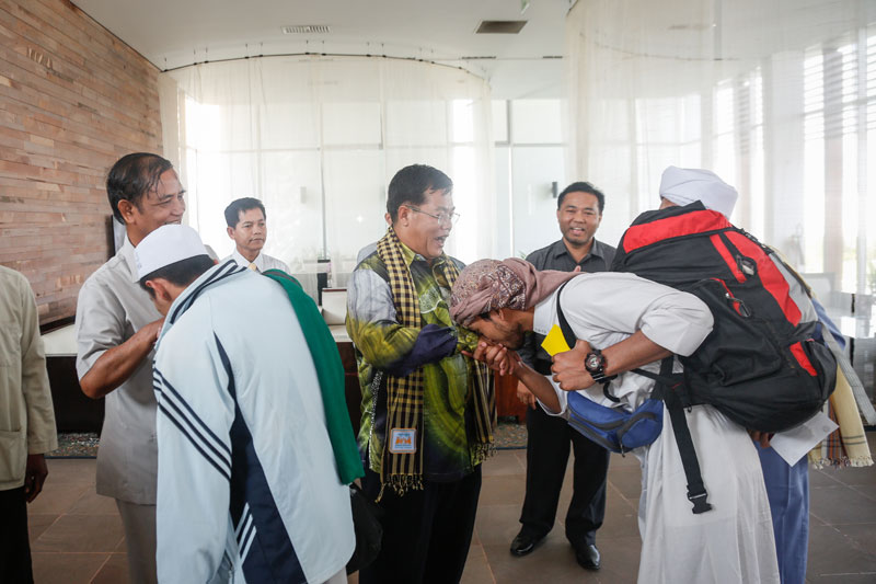 Tort Pilil kisses the hand of Othsman Hassan, a Labor Ministry official who helped arrange the evacuation of 16 Cambodian students from Yemen, after arriving at Phnom Penh International Airport on Tuesday afternoon. (Siv Channa/The Cambodia Daily)