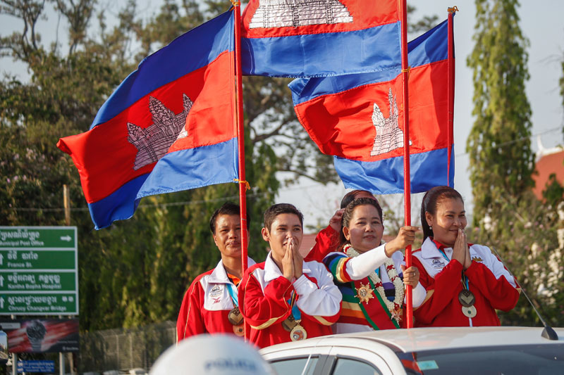 Ke Leng, who won a gold medal at the Petanque World Championship in 2013, holds a Cambodian flag during a procession to celebrate her achievement in Phnom Penh on Thursday. (Siv Channa/The Cambodia Daily)