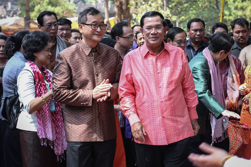 Opposition leader Sam Rainsy, left, and Prime Minister Hun Sen tour exhibits at the Angkor Sankranta festival in Siem Reap City last week. (Alex Willemyns/The Cambodia Daily)